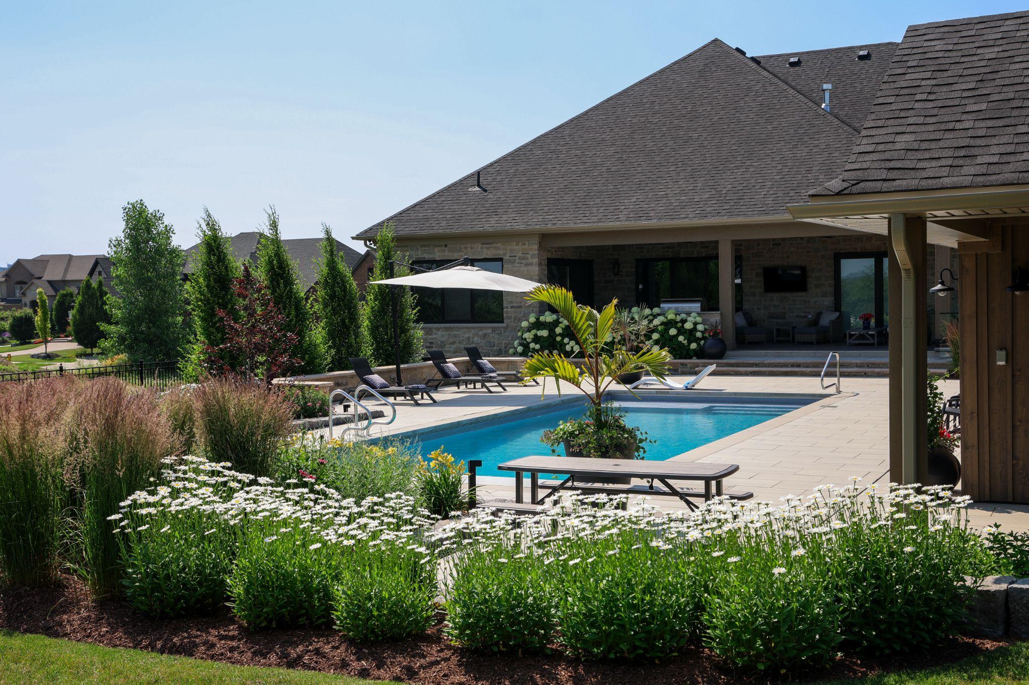 A house with a pool and flowers.