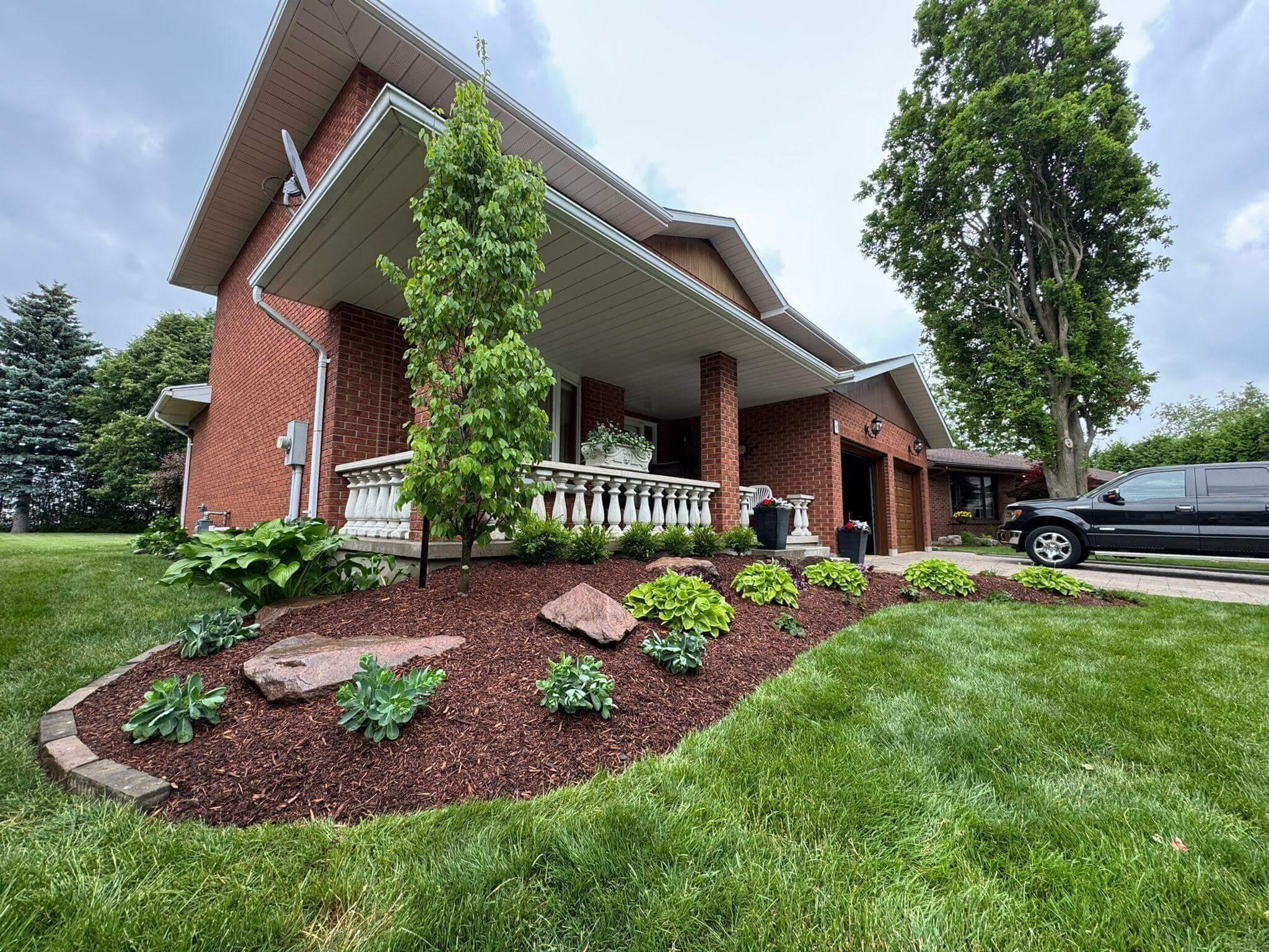 A modern house with front yard landscaping and a parked car.