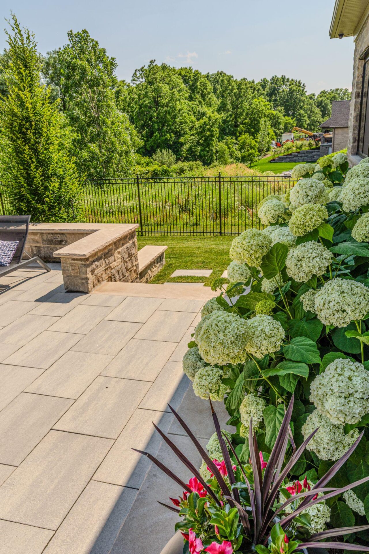A patio with hydrangeas and custom stonework.
