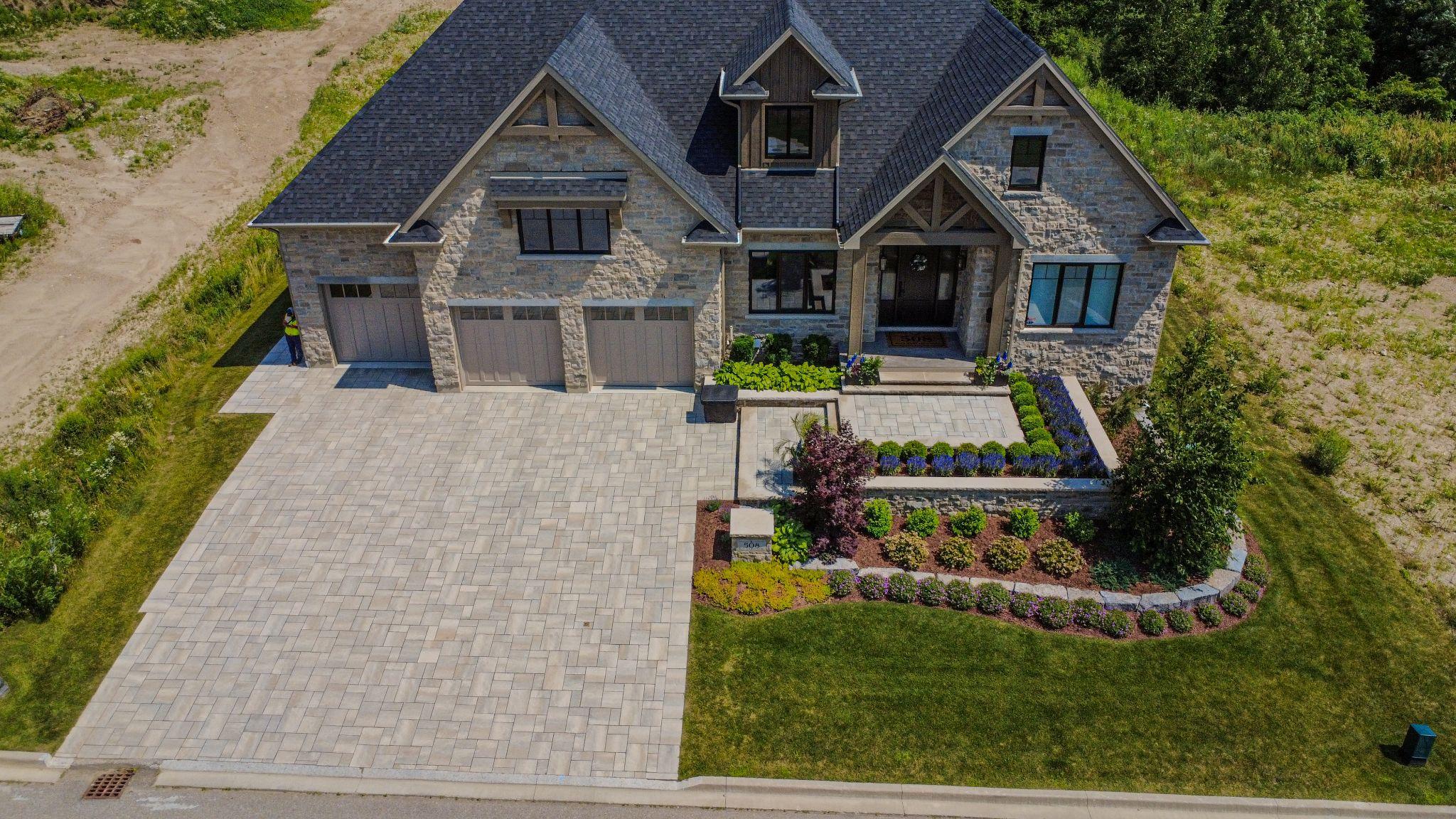 An aerial view of a house with a landscaped driveway