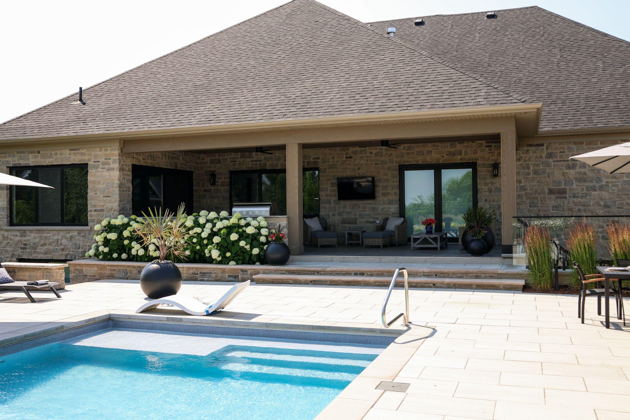 A modern backyard with pool and patio furniture for stylish outdoor living.